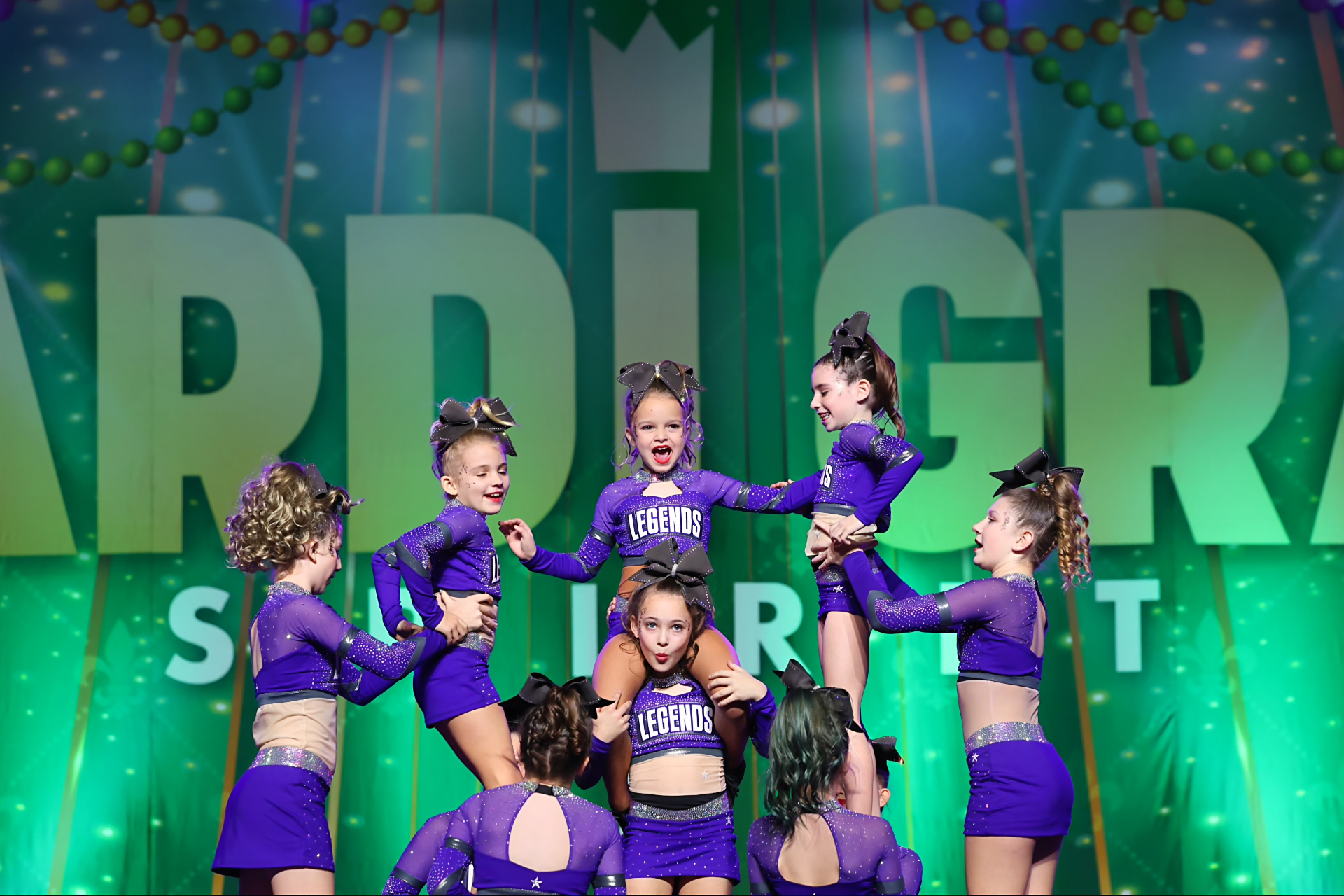All star cheerleaders and gymnasts performing under arena lights